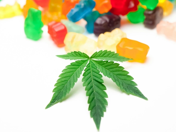 Cannabis cookies and pot leaf on oak table