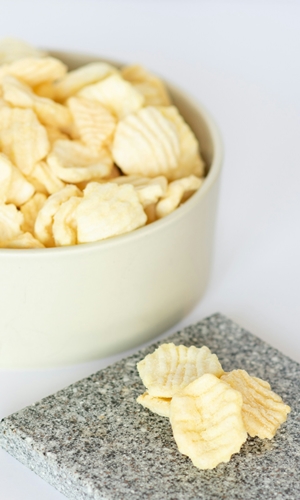 Bowl of chips beside granite tile plate